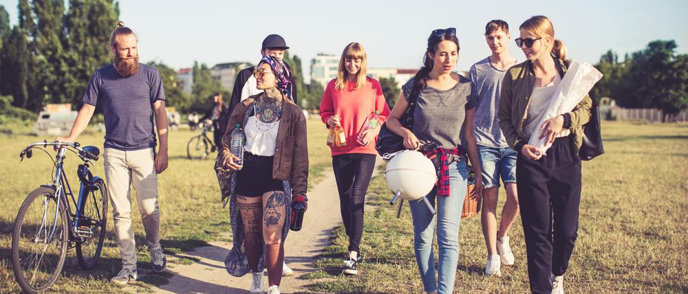 Multiracial friends going on picnic in city park
