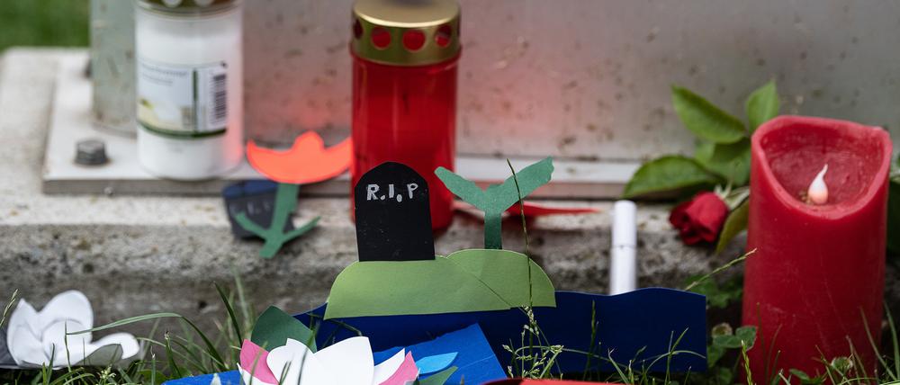 Kerzen und gebastelte Blumen liegen vor einer Stele an der Haupt- und Realschule Kaulbach-Schule im nordhessischen Bad Arolsen.