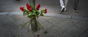 Blumen erinnern an die Opfer der Amokfahrt, während das Leben drumherum weitergeht.
