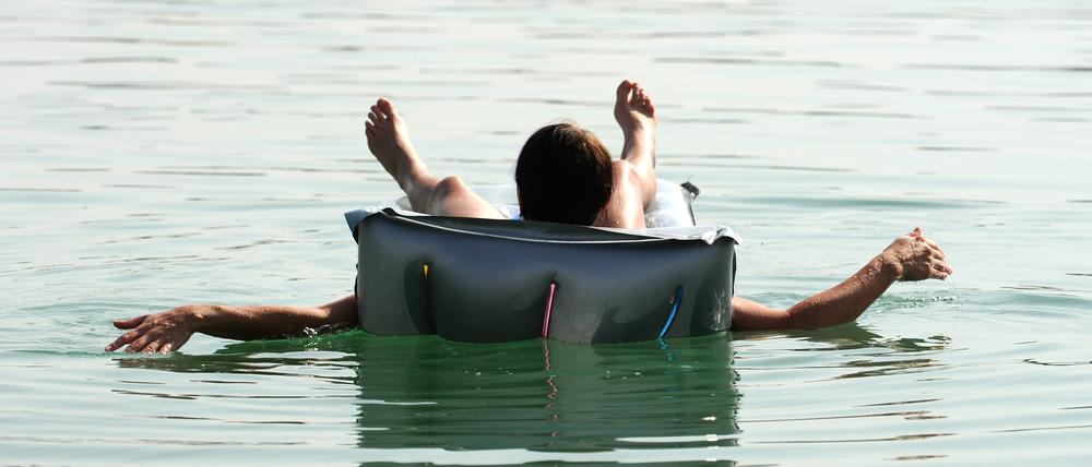 Eine junge Frau liegt am Montag (22.08.2011) bei strahlendem Sonnenschein auf einer Luftmatratze auf einem Baggersees bei Dingolfing und sonnt sich. Foto: Andreas Gebert dpa/lby ++ +++ dpa-Bildfunk +++