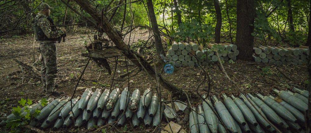 Ein ukrainischer Soldat steht neben in den Wäldern nahe der Provinz Saporischschja versteckten Haubitzen-Munition, die für den Beschuss der russischen Stellungen vorbereitet wurden. 