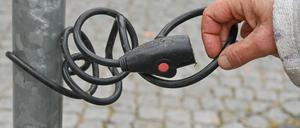 Vom Fahrrad ist nichts mehr zu sehen: ein altes Fahrradschloss, angeschlossen an einem Mast. 