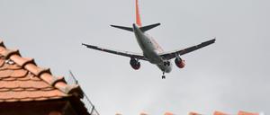 ARCHIV - Ein Passagierflugzeug fliegt am 17.08.2014 in Berlin-Bohnsdorf während des Landeanfluges auf den Flughafen Schönefeld (Dahme-Spreewald) dicht über den Hausdächern.  Die Präsentation eines weiteren Maßnahmenpakets für den aktiven Schallschutz am Frankfurter Flughafen verzögert sich. (Zu dpa «Maßnahmenpaket zum aktiven Schallschutz kommt etwas später» vom 02.12.2017) Foto: Patrick Pleul/dpa-Zentralbild/dpa +++(c) dpa - Bildfunk+++