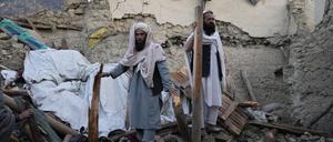 23.06.2022, Afghanistan, Gayan: Zwei Afghanen stehen in den Trümmern eines Hauses. Nach dem verheerenden Erdbeben in der afghanisch-pakistanischen Grenzregion hat Regen die Rettungsarbeiten erschwert. Foto: Ebrahim Noroozi/AP/dpa +++ dpa-Bildfunk +++