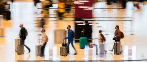 Passagiere mit Rollkoffern gehen am Flughafen Berlin Brandenburg „Willy Brandt“ (BER) durch das Terminal 1. 