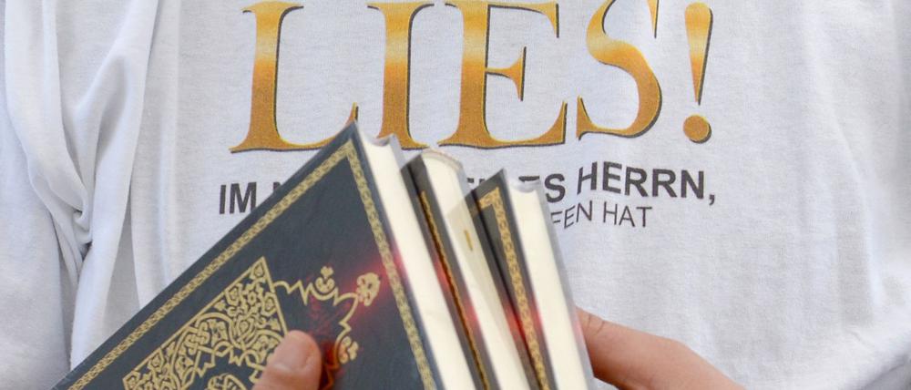 Ein Islamist verteilt am Potsdamer Platz in Berlin kostenlose Koran-Exemplare an Passanten. Die Koran-Verteilung wurde von den radikalislamischen Salafisten initiiert.