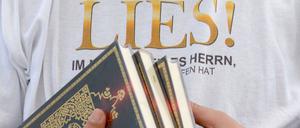 Ein Islamist verteilt am Potsdamer Platz in Berlin kostenlose Koran-Exemplare an Passanten. Die Koran-Verteilung wurde von den radikalislamischen Salafisten initiiert.