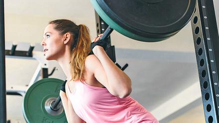 Frauen üben in reinen Frauen-Fitnessstudios auch mal traditionell männlich dominierte Sportübungen mit Hanteln aus.