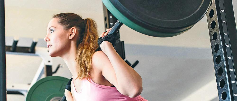 Frauen üben in reinen Frauen-Fitnessstudios auch mal traditionell männlich dominierte Sportübungen mit Hanteln aus.