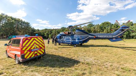04.07.2022, Brandenburg, Byhlen: Ein Löschhubschrauber der Bundespolizei steht in einer Wartungspause auf einer Wiese. Der Waldbrand in der Lieberoser Heide breitet sich nach Einschätzung des Landkreises aus. Das Feuer in dem mit Munition belasteten Gebiet wurde als «Großschadenslage» eingestuft, wie der Landkreis Dahme-Spreewald mitteilte. Foto: Frank Hammerschmidt/dpa +++ dpa-Bildfunk +++