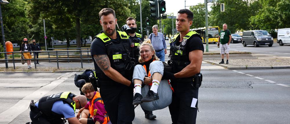 Tägliche Routine: Vorsichtig lösen Polizisten die Blockierer von der Straße und tragen sie weg.