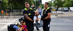 Tägliche Routine: Vorsichtig lösen Polizisten die Blockierer von der Straße und tragen sie weg.