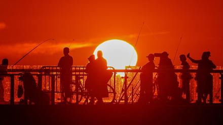 People stand on a pier during sunset in the Baltic Sea resort of Zelenogradsk in the Kaliningrad region, Russia June 23, 2022. Picture taken June 23, 2022. REUTERS/Vitaly Nevar