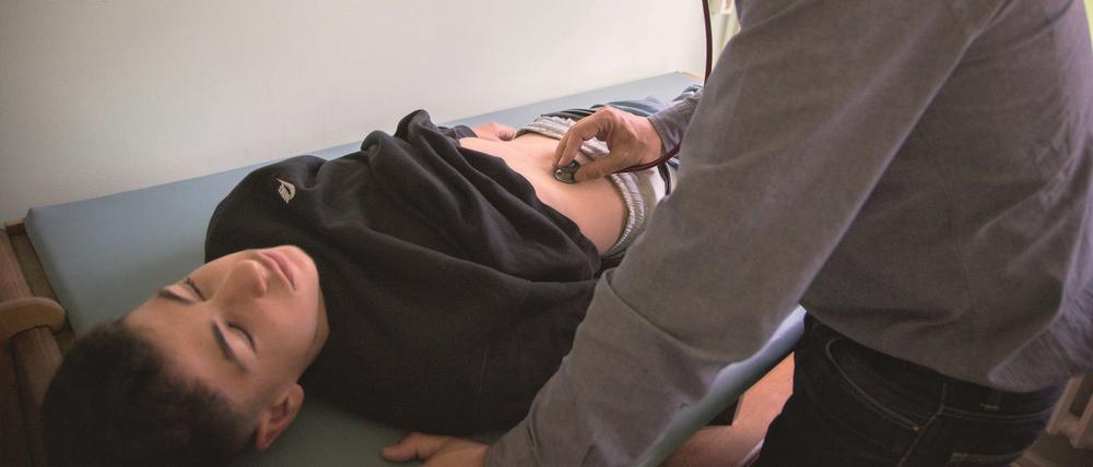 Kinderarzt Jakob Maske hört den Bauch seines Patienten Berat ab.