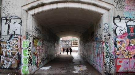 Menschen gehen durch die Unterführung zum Monbijoupark in Mitte, in der Unbekannte eine Rose und eine Kerze abgelegt haben. Ein 13-jähriger Junge war hier in der Nacht bei dem Streit tödlich verletzt worden. Ein unbekannter Mann soll das Kind mit einem Messer angegriffen und einen weiteren jungen Mann schwer verletzt haben, wie die Staatsanwaltschaft bestätigte. +++ dpa-Bildfunk +++