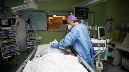 Lorenz Nowak, Chefarzt der Klinik für Intensivmedizin, arbeitet in Schutzkleidung in einem Intensivbett-Zimmer in der Asklepios Klinik am Bett eines über einen Luftröhrenschnitt beatmeten Corona-Patienten.