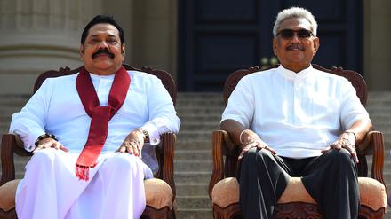 (FILES) In this file photo taken on November 22, 2019, Sri Lanka's new President Gotabaya Rajapaksa (R) and his Prime Minister brother Mahinda Rajapaksa, pose for a group photograph after the ministerial swearing-in ceremony in Colombo. - Millions of rupees in cash left behind by President Gotabaya Rajapaksa when he fled his official residence in the capital will be handed over to court on July 11, 2022, police said. (Photo by ISHARA S. KODIKARA / AFP)