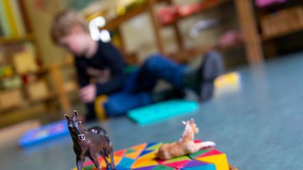 Ein Junge spielt in einem Brandenburger Kindergarten auf dem Boden. 