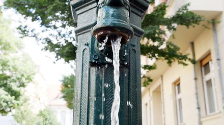Eine Pumpe am Straßenrand gibt Wasser für trockene Bäume.