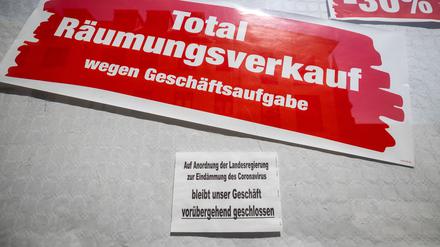 ARCHIV - 16.04.2020, Thüringen, Meiningen: Ein Schild an einem Geschäft weist darauf hin, dass es auf Anordnung der Landesregierung zur Eindämmung des Coronavirus geschlossen ist, darüber hängt ein weiteres Schild mit der Aufschrift «Total-Räumungsverkauf wegen Geschäftsaufgabe». (zu dpa «Lambrecht will Firmensanierung ohne Insolvenzverfahren erleichtern») Foto: Michael Reichel/dpa-Zentralbild/dpa +++ dpa-Bildfunk +++ | Verwendung weltweit