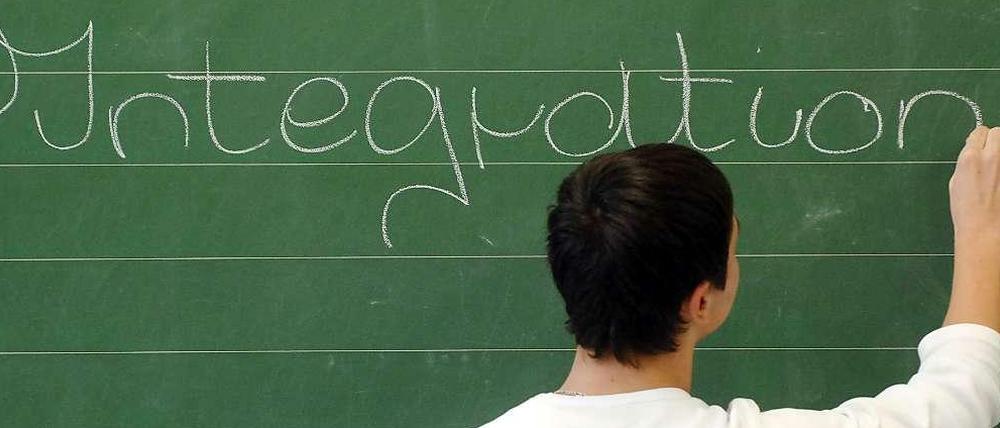 Ein Schüler schreibt das Wort Integration an die Tafel.