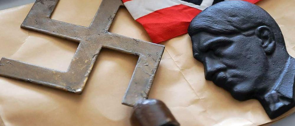Redikte aus Hitlers Refierungszeiten: Ein bronzenes Hakenkreuz, eine NS-Fahne und eine Hitler Büste