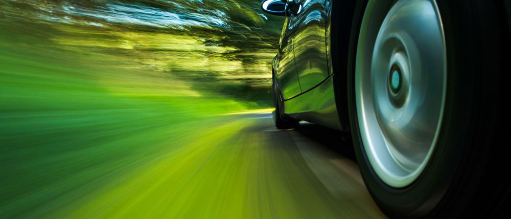Auto fährt auf einer Landstraße durch die Natur.