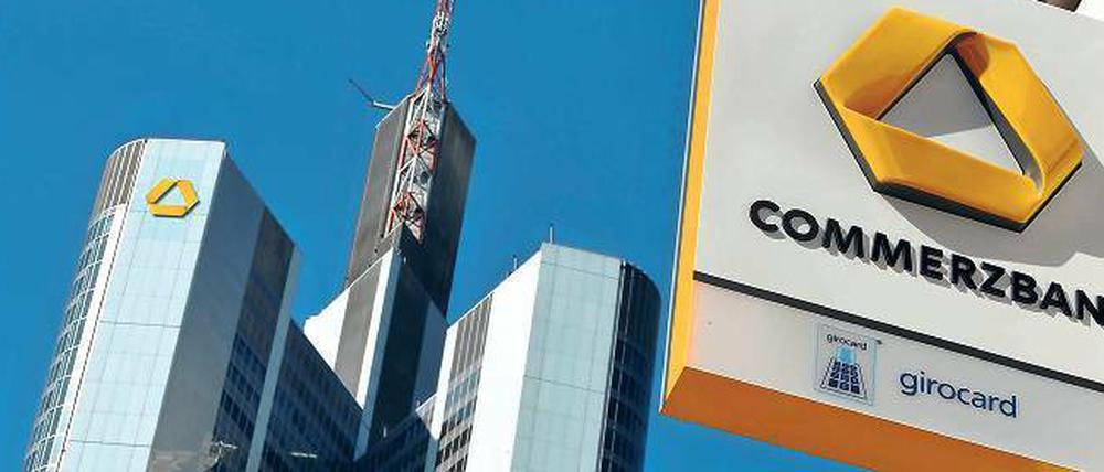 Schild einer Commerzbank-Filiale, im Hintergrund: Die Frankfurter Zentrale