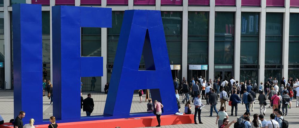 Besucher warten vor dem Eingang der IFA und fotografieren den großen IFA-Schriftzug.