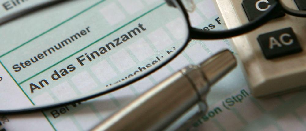 Eine Steuererklärung, ein Taschenrechner, eine Brille und ein Kugelschreiber