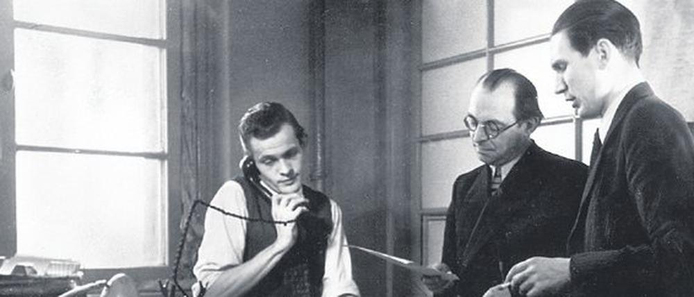 1949. Trotzdem muss das Tagesgeschäft weitergehen: Chefredakteur Erik Reger (rechts) bei der Planungskonferenz der Nachrichtenredaktion im Ullstein-Haus. In der Mitte steht Theaterkritiker und Mitherausgeber Walther Karsch.