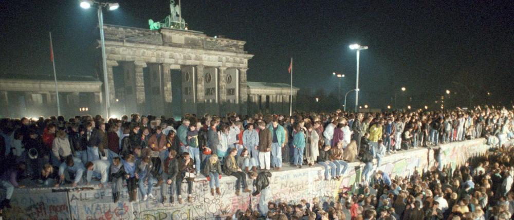 Menschen auf der Berliner Mauer vor dem Brandenburger Tor in der Nacht vom 9. auf den 10.11.1989.