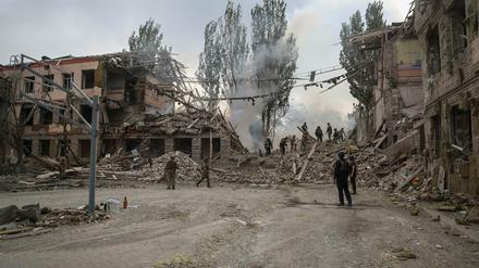 Aufbauarbeiter räumen Ruinen einer zerstörten Schule in Kramatorsk auf.
