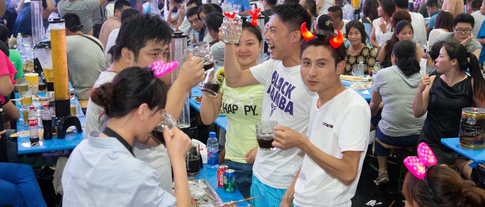 Besucher feiern am 16.08.2014 beim Oktoberfest im chinesischen Qingdao.