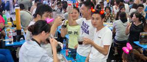 Besucher feiern am 16.08.2014 beim Oktoberfest im chinesischen Qingdao.