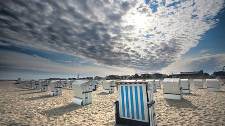 dpatopbilder Über den Strandkörben des Ostseebades Rostock-Warnemünde (Mecklenburg-Vorpommern) kämpft sich die Sonne am 25.08.2015 durch die Wolken. Das hochsommerliche Wetter ist vorerst vorbei. Foto: Bernd Wüstneck/dpa +++(c) dpa - Bildfunk+++