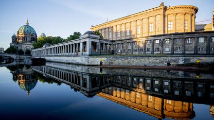 Die Alte Nationalgalerie und der Berliner Dom spiegeln sich in der Spree.