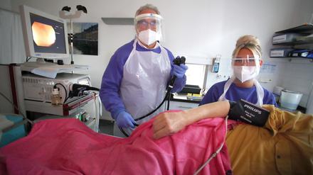 Andreas Schroeder, Gastroenterologe, bei einer ambulanten Vorsorgekoloskopie mit Coronahygiene-Massnahmen in Schutzkleidung bei einer Darmspiegelung, in seiner Praxis in Berlin.