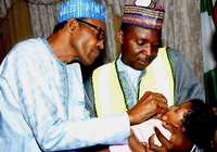 Der 72-jährige Präsident Muhammadu Buhari impft seine drei Monate alte Enkeltochter Zuleiha gegen Polio. Erst im September will der seit Mai amtierende Präsident eine Regierung benennen.