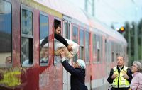 Eine ältere Frau reicht am Bahnhof in Freilassing (Bayern) einem mit einem Sonderzug aus Wien angekommenen Flüchtling eine von ihr gespendete Decke durch das Fenster des Waggons, bevor er nach einer kurzen Registrierung weiter nach Hanau fährt.