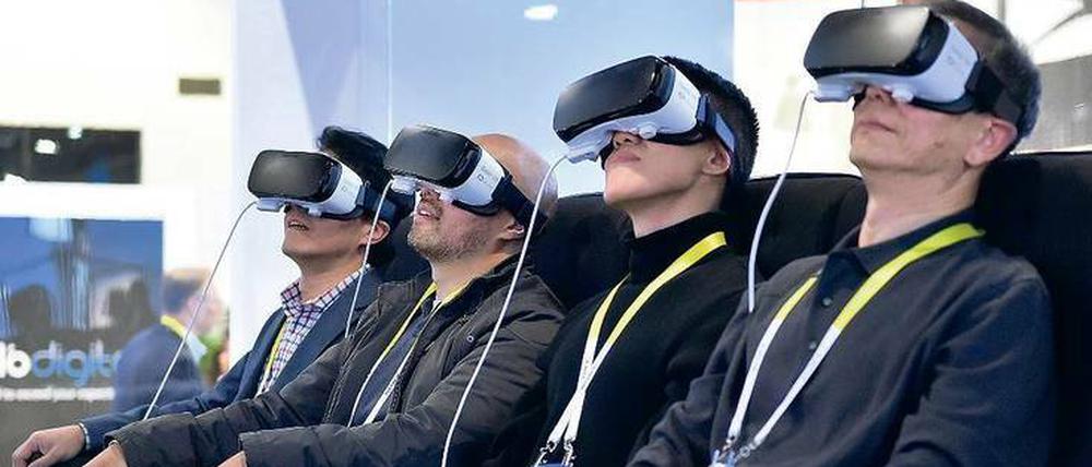 Nicht ganz von dieser Welt. 2016 wird das Jahr von VR-Brillen wie Samsung Gear (im großen Bild), Oculus Rift oder HTC Vive – auch wenn deren Träger seltsam entrückt in eine nur für sie sichtbare Zukunft schauen.