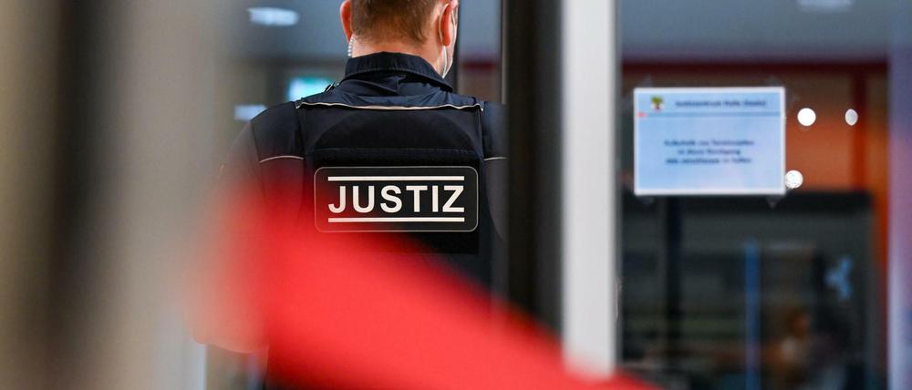 Ein Justizmitarbeiter steht hinter einer Sicherheitsschleuse. (Archivbild)