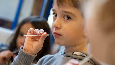 Kinder in einer Kita machen einen Lollitest - in Berlin machen ihn die Eltern meist Zuhause.