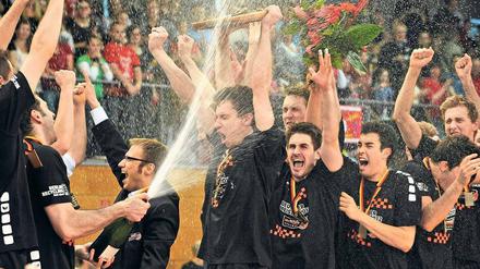 Duscher-Meister. Nach dem Sieg im entscheidenden fünften Finalspiel bespritzen sich die Spieler der Volleys mit Sekt und halten die Meisterschale hoch. Foto: dapd