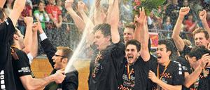 Duscher-Meister. Nach dem Sieg im entscheidenden fünften Finalspiel bespritzen sich die Spieler der Volleys mit Sekt und halten die Meisterschale hoch. Foto: dapd