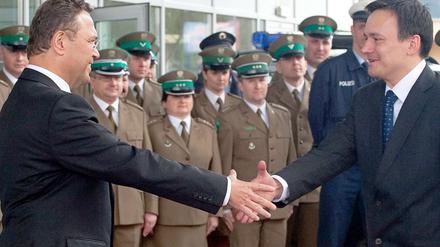 Bundesinnenminister Hans-Peter Friedrich (CSU, l.) und sein polnischer Amtskollege Jacek Cichocki (r.) geben sich am Montag (23.04.12) in Swiecko in Polen an der deutsch-polnischen Grenze bei der Eröffnung einer gemeinsamen Dienststelle des polnischen Grenzschutzes und der Bundespolizei die Hand.