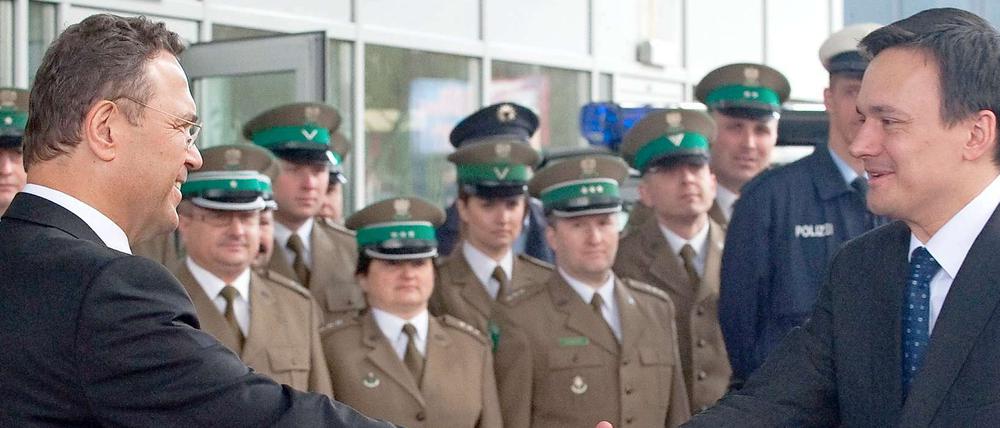 Bundesinnenminister Hans-Peter Friedrich (CSU, l.) und sein polnischer Amtskollege Jacek Cichocki (r.) geben sich am Montag (23.04.12) in Swiecko in Polen an der deutsch-polnischen Grenze bei der Eröffnung einer gemeinsamen Dienststelle des polnischen Grenzschutzes und der Bundespolizei die Hand.