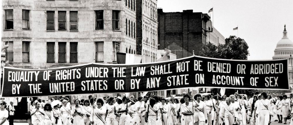 Frauen tragen ein Banner auf einer Demonstration für den ERA.