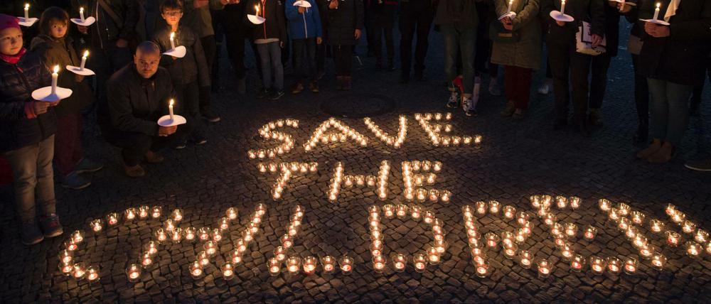 "Save the children" steht mit Kerzen gestaltet auf dem Boden vor dem Brandenburger Tor. 