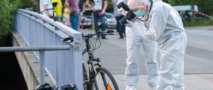 Ein Ermittler der Polizei fotografiert am Sonntag in Hamburg-Bergedorf in der Nähe des Allermöher Badesees am Tatort ein Fahrrad. 